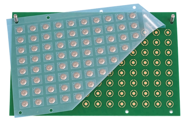 Peel-and-place dome array aligned to circular PCB contact pads with tooling pins